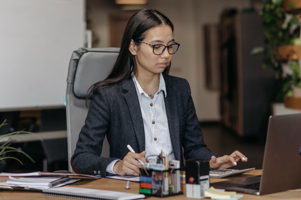Younger remote professional focused at her desk, running the operating layer